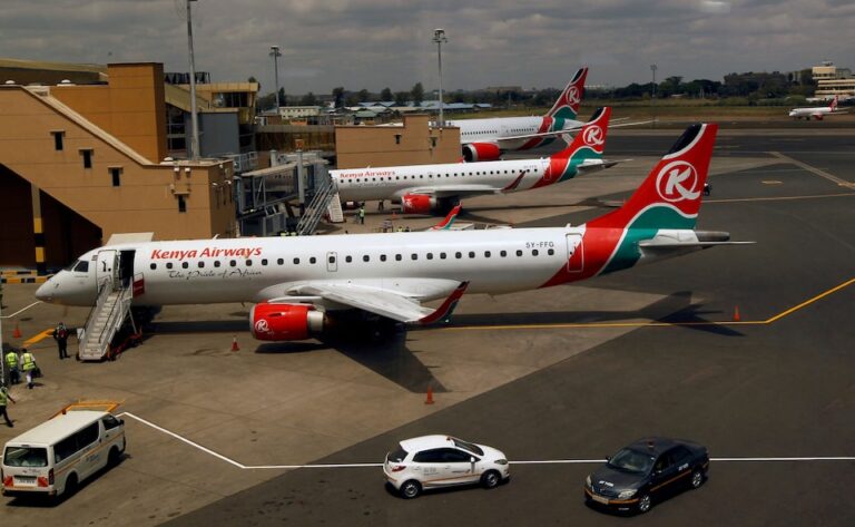 Kenya Airways planes are seen through a window at the Jomo Kenyatta international airport | REUTERS/Njeri Mwangi