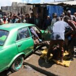 Volunteers retrieve the body of a man from a car after heavy rains in Nairobi | Andrew Kasuku / AP