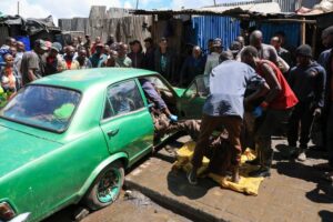 Volunteers retrieve the body of a man from a car after heavy rains in Nairobi | Andrew Kasuku / AP