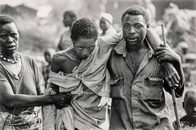 Rwandans walk across the border and into refugee camps. Many had machete cuts or cholera, and refugees continued to die for weeks after in the camps.